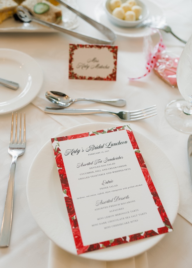 A menu with a red rose border that says "Kirby's Bridal Luncheon" with the menu. 