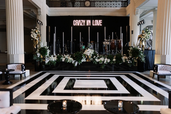 White florals and greenery decorate the stage at the sophisticated black tie wedding in Houston.