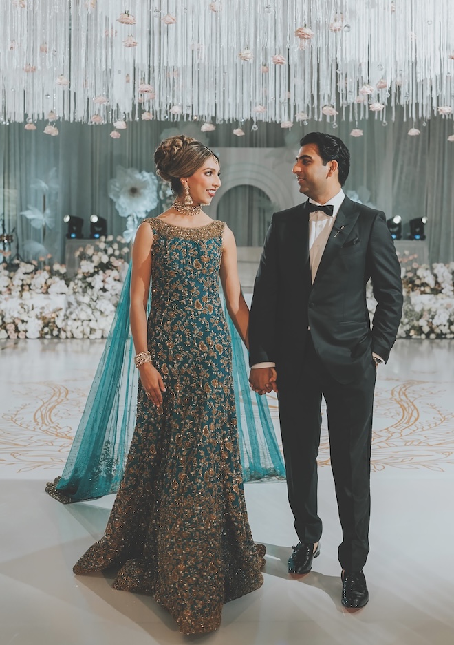 The couple hold hands at their floral-filled wedding at The Post Oak Hotel at Uptown Houston.