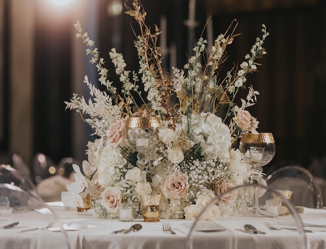 Floral arrangements with peach and white flowers are centered on the tables.