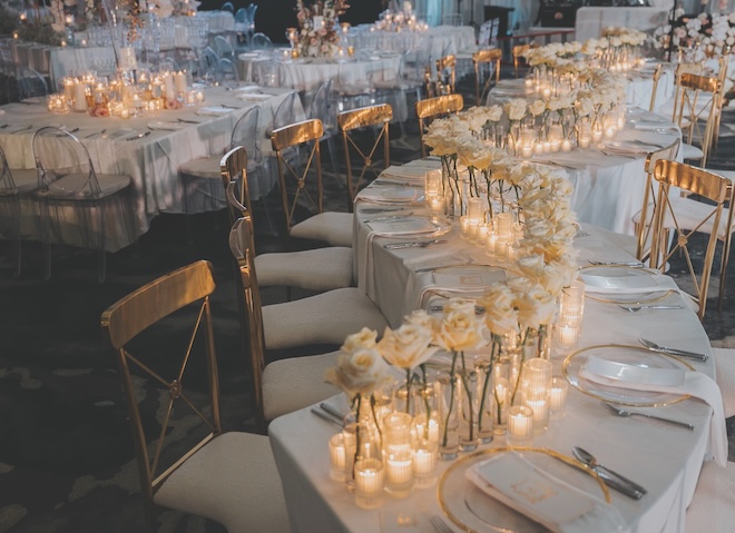 Single stemmed white roses and candlelight decorate the reception tables.