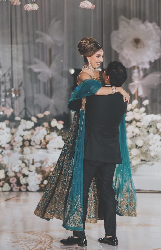 The groom picks up the bride as they dance at their wedding reception.