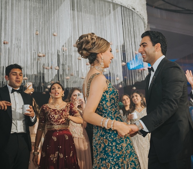 The couple dance beside their family and friends. 
