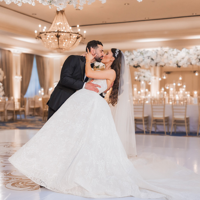 Groom dipping the bride in the middle of the dancefloor at glamorous gold wedding at Houstonian.
