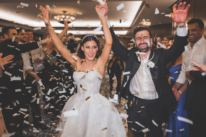 Newlyweds making grand exit with confetti thrown by guests following their glamorous gold wedding at Housotnian.