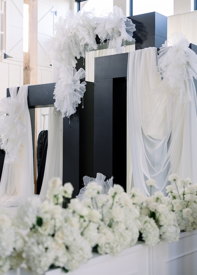 Black pillars with white draping for Ashley and Alex's wedding on Love Is Blind.