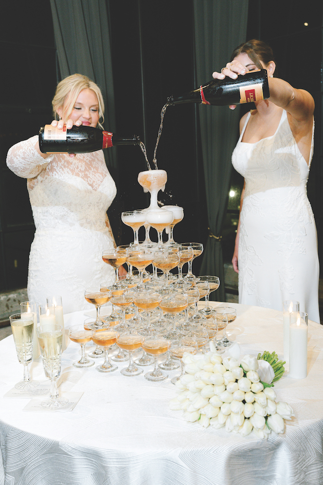 Newlyweds filling their champagne tower at reception.