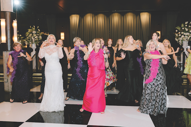 Mother of the brides dancing together with other members of wedding party on the dance floor at reception.