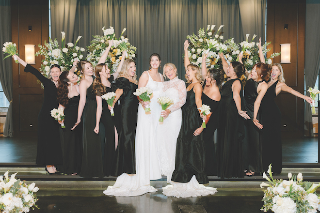 Newlyweds standing with wedding party for their spring wedding with white blooms.