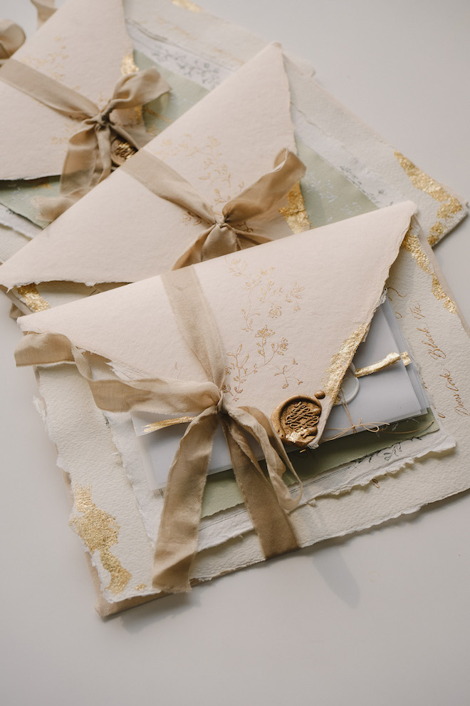 Vintage cardstock with gold details with ribbon stationery for unique wedding invitation ideas.