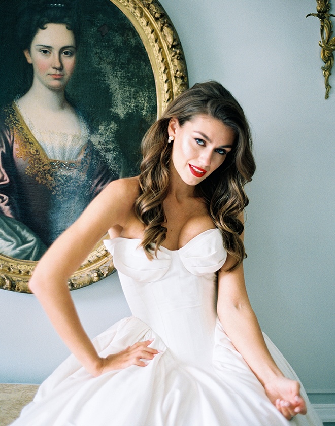 The bride poses in front of a old-time painting in Paris. 