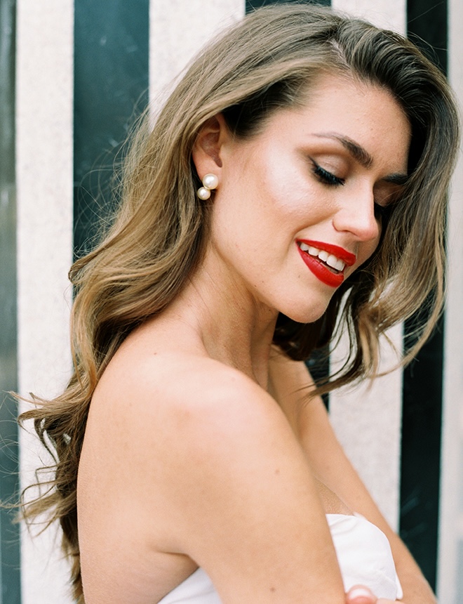 The bride smiles wearing red lipstick. 