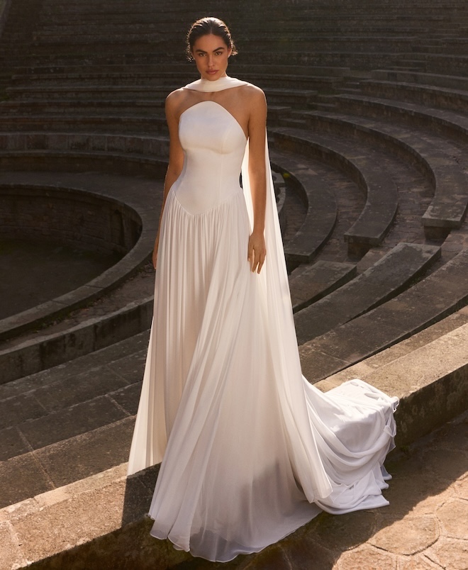 The model wears a flowy wedding gown by Pronovias from their spring 2027 bridal looks featured at New York Bridal Fashion Week. 