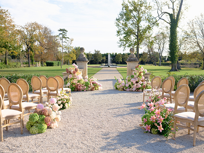 Pink and green florals decorate the aisle and alter of the outdoor ceremony. 