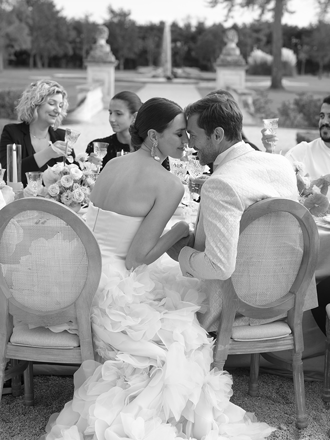 The couple hold hands at their wedding reception. 