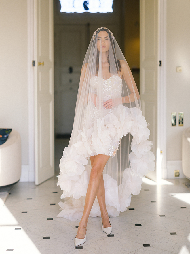 The model wears a veil outlined in blooms.