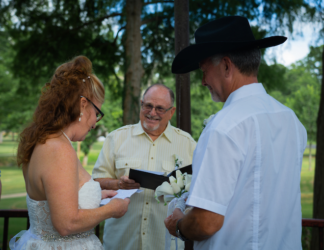 Bride and groom reading each other vows at beautiful intimate wedding reception.