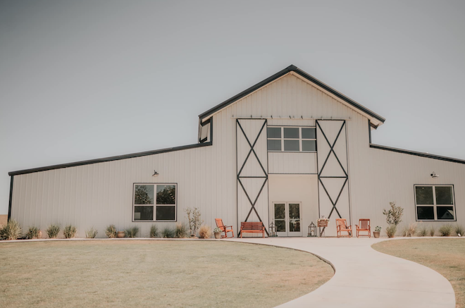 White barndominium with black details for hill country wedding venues.