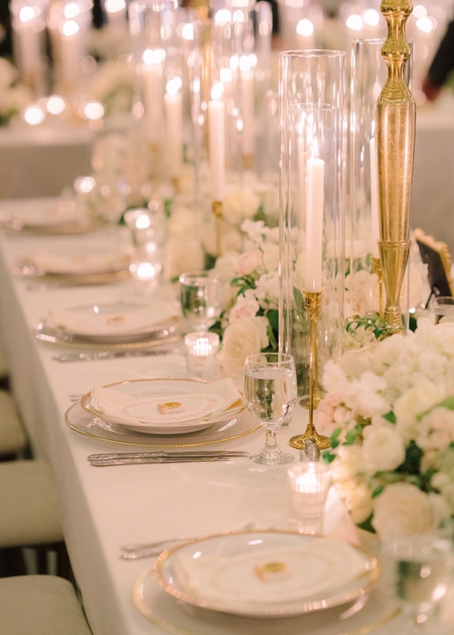 White flowers and candles decorate the reception tables at the couples Le Tesserae wedding.