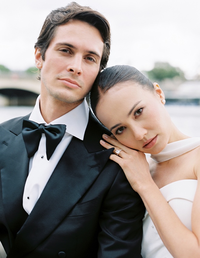 The bride and groom pose on a boat as they float down the Seine for their Paris wedding photography.