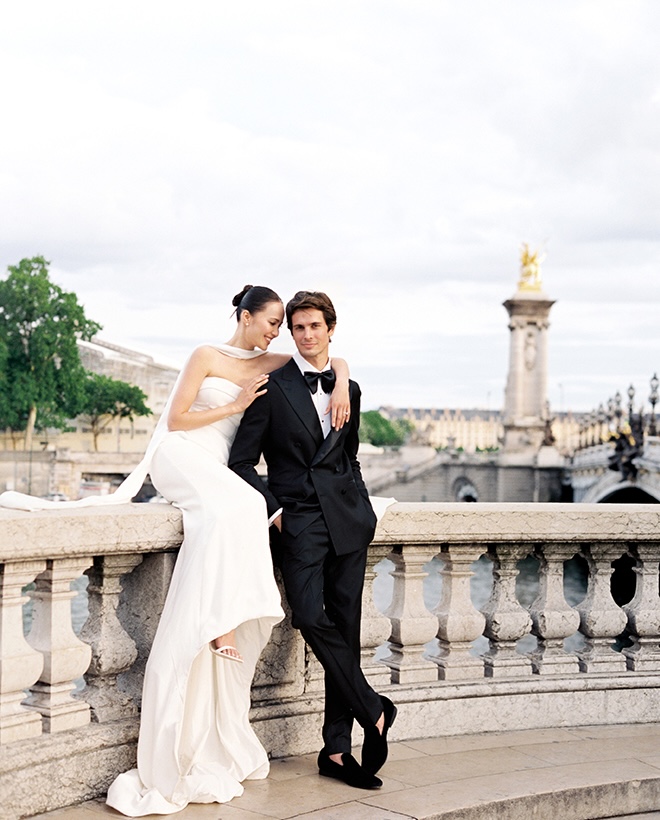 For their Paris wedding photography, the couple sit on the ledge of Paris architecture. 