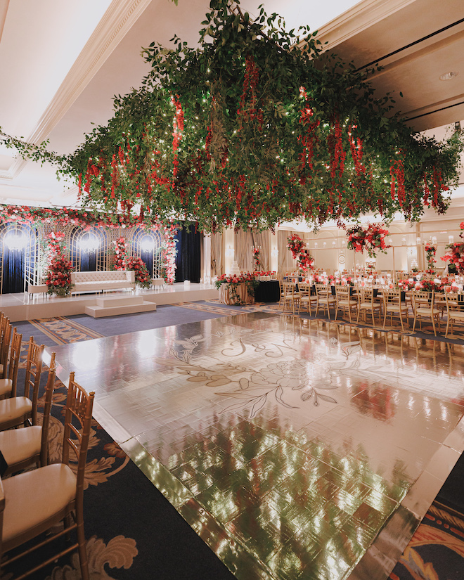 Red floral adorned reception ballroom with red, green, and gold details.