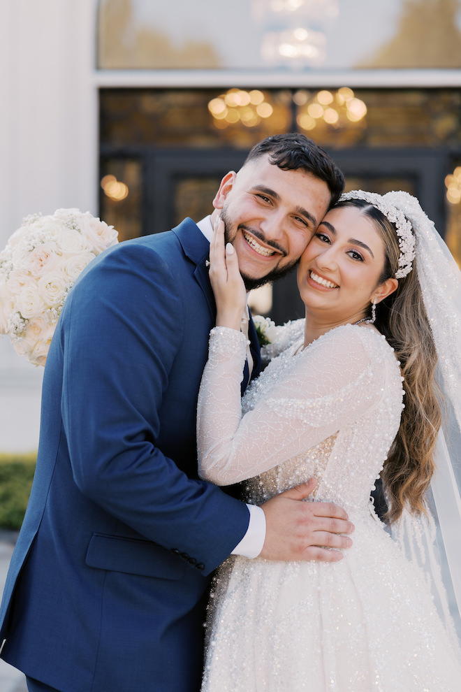 Newlyweds up close and smiling with their faces pressed together.