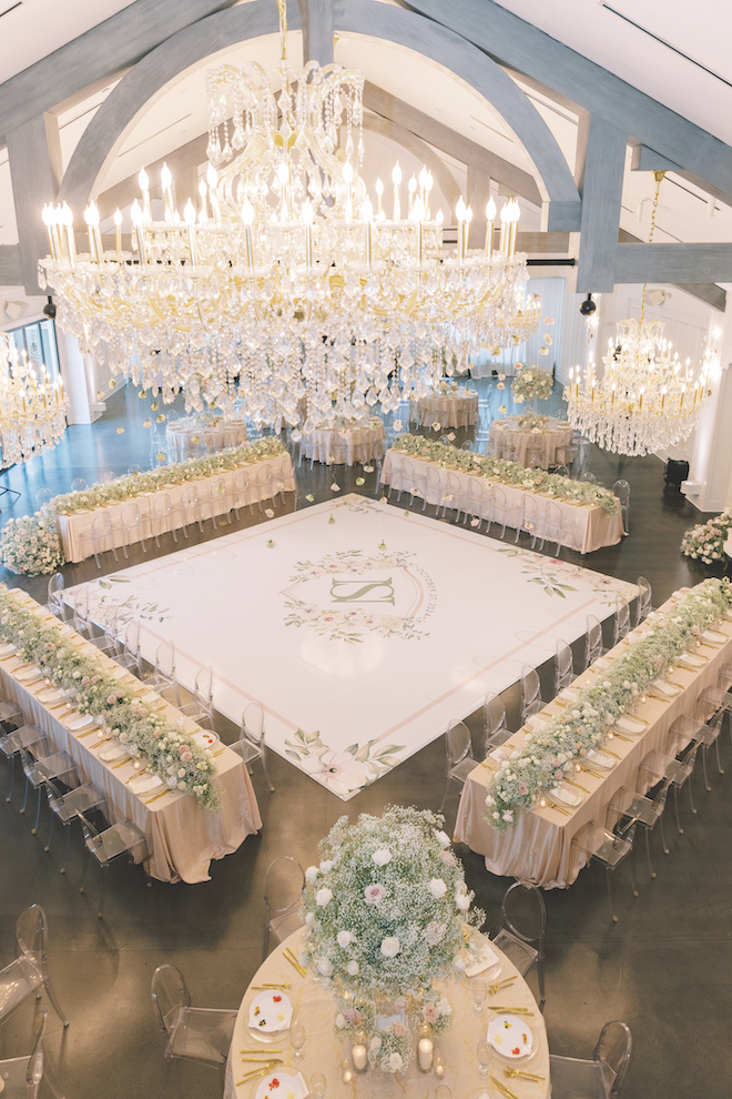 Aerial view of reception venue with glass chandeliers and intimate white dance floor with floral details.
