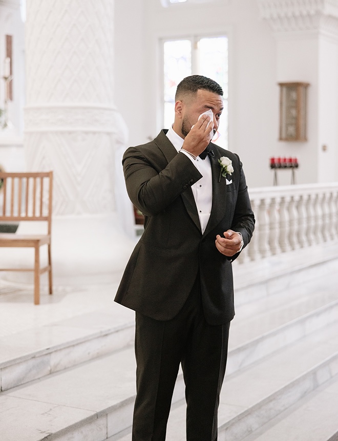 The groom wipes tears from his eyes at his Galveston wedding ceremony. 