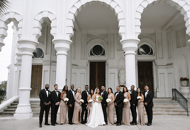 The couple and their wedding party stand outside their church ceremony.