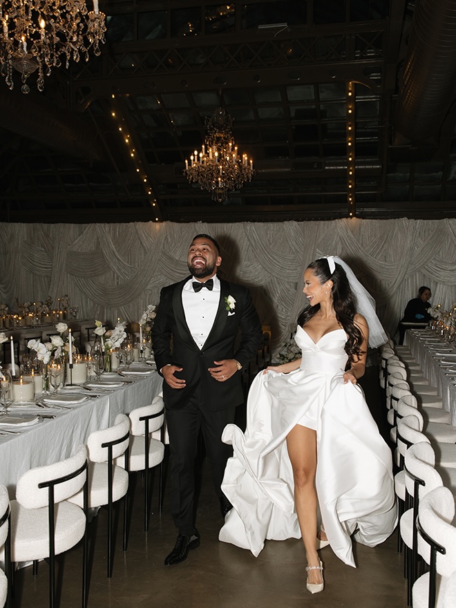 The bride and groom run down the aisles of their wedding reception.