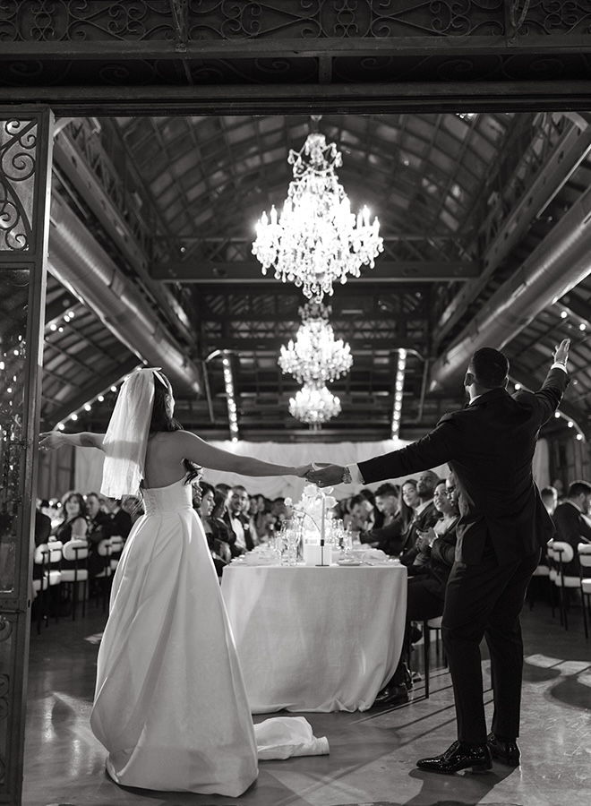 The couple dance at their wedding reception as wedding guests watch. 