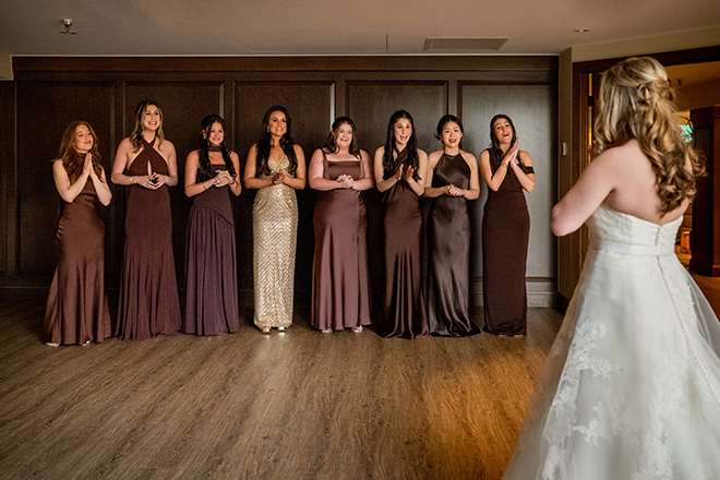 The bridesmaids react to seeing the bride for the first time in her wedding dress.