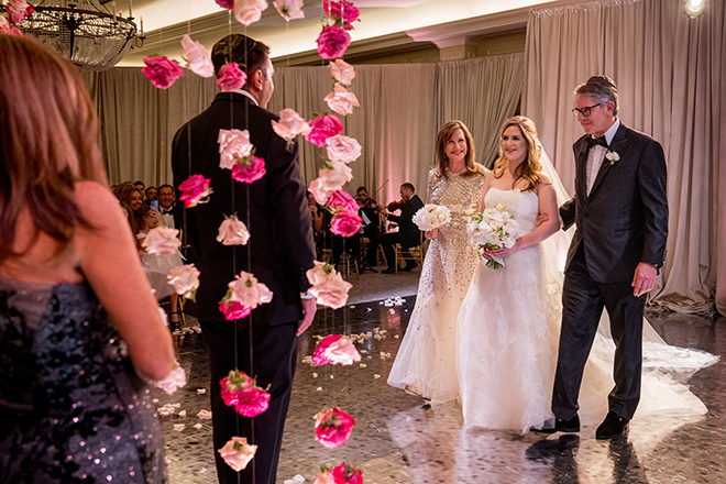 The bride's parents give her away to the groom at their Jewish wedding ceremony in Houston. 