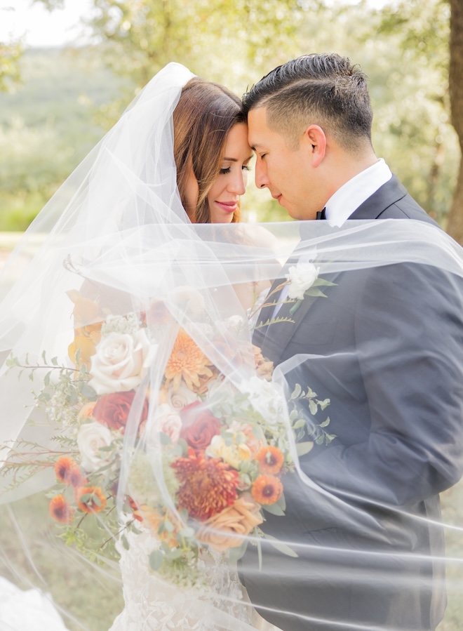 Elizabeth B Photography embrace under the bride's wedding veil.
