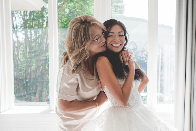 Bride and mother of the bride hugging together before Station 3 wedding.