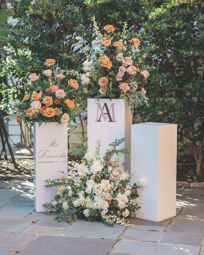 Three white pillars with colorful florals coming out of it for Station 3 wedding entrance.