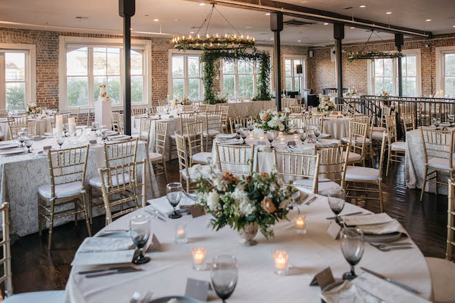 Reception decor with floral bouquets as the centerpieces and candles.