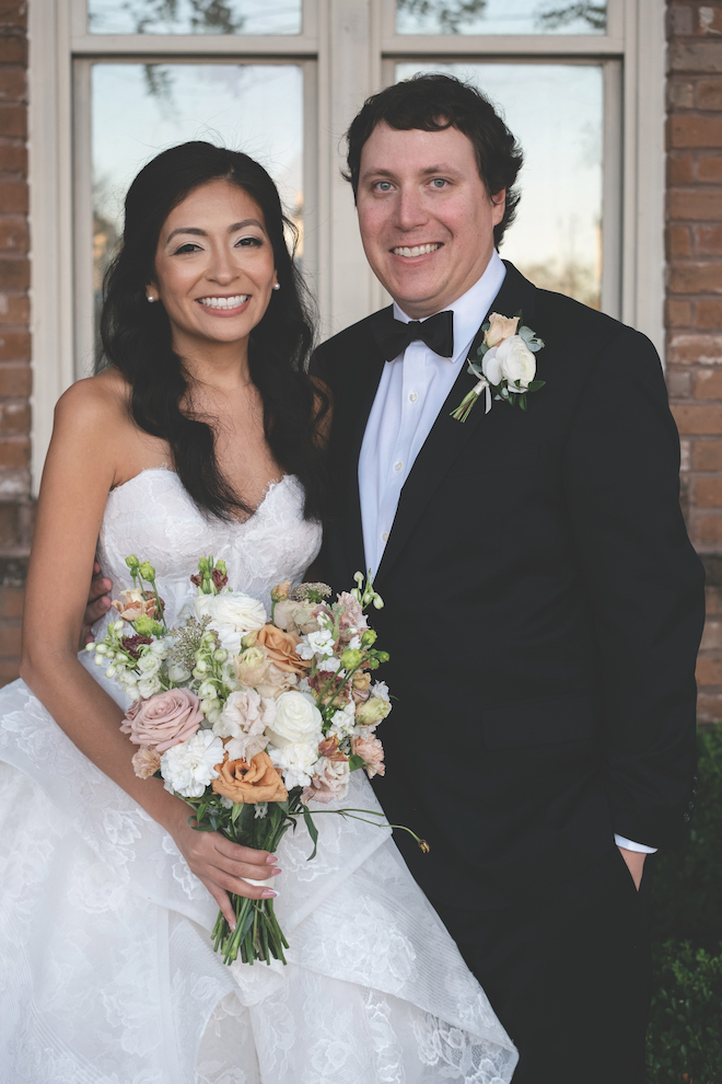 Bride and groom outside of brick venue.
