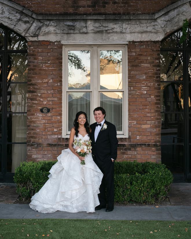 Newlyweds outside of brick venue.