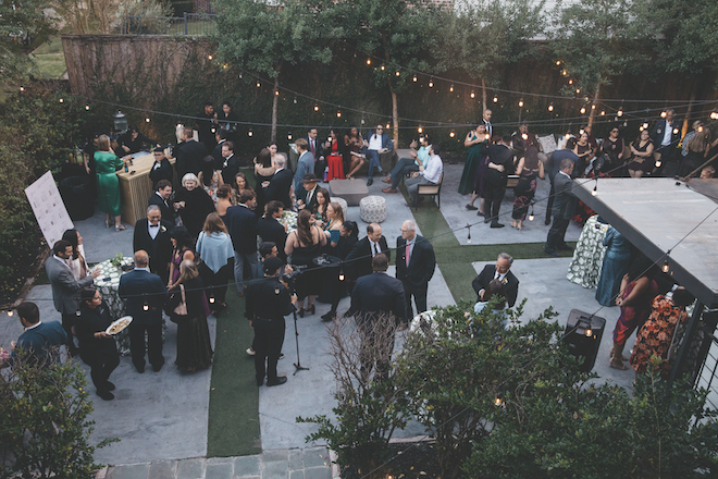 Above shot of guests at an outdoor cocktail hour with string lights for Station 3 wedding.