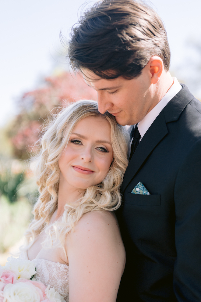 Close up of groom behind bride while she smiles.