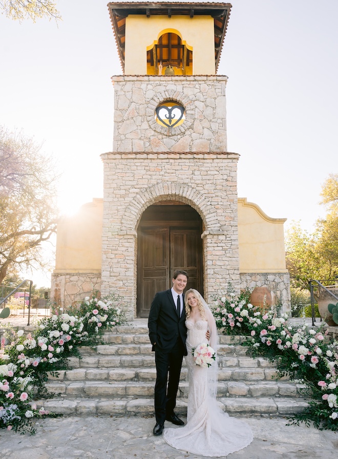 The bride and groom stand in front of the church at Camp Lucy in Austin. 