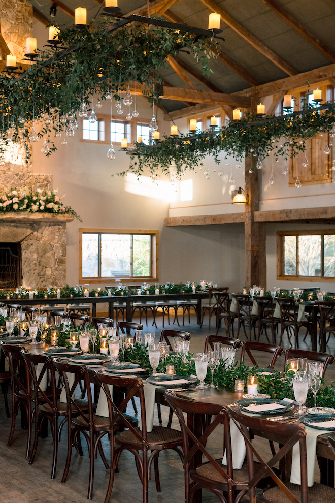 Inside of reception with greenery and white accents all around.