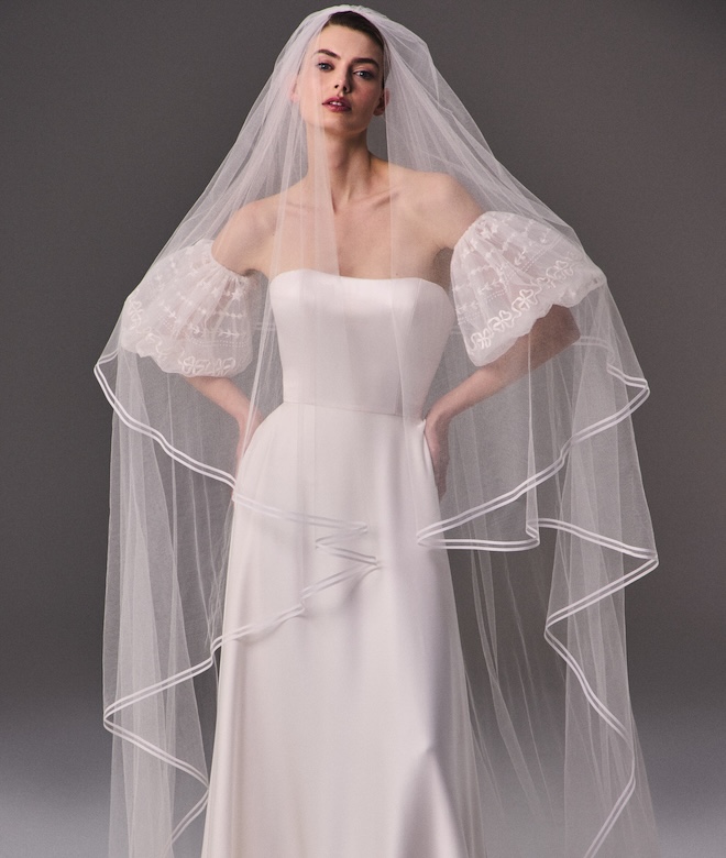 The model wears a multi-tiered wedding veil that is sheer. 