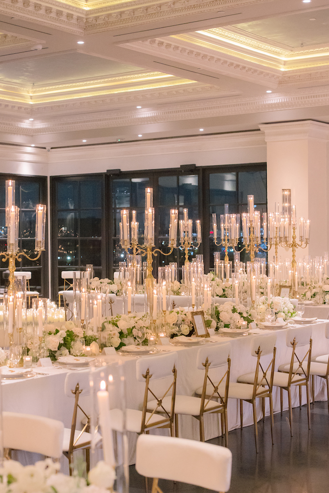 Candle lit reception tables with stunning florals all in white for luxury wedding details.