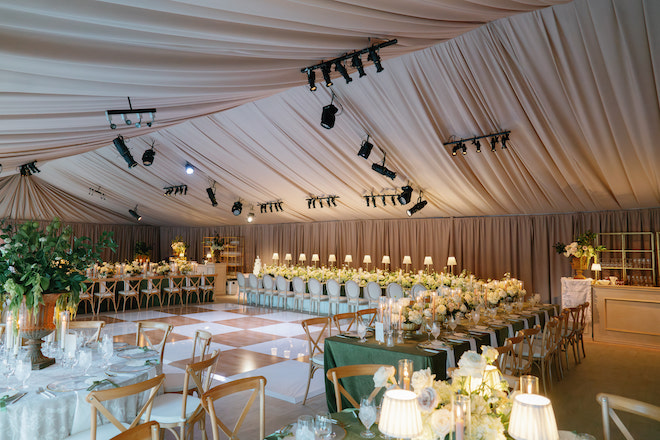 Open floor surrounded by tables with florals and burnt orange and white checkered floor.