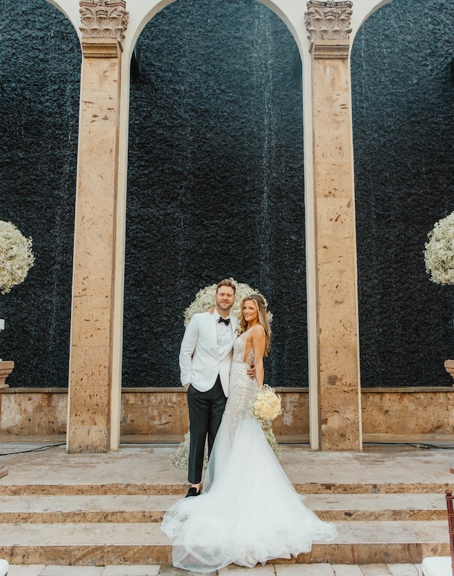 The bride and groom pose in front of the Waterwall at The Bell Tower on 34th. 