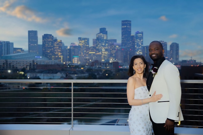 The couple smile on the terrace of Le Tesserae overlooking the Houston skyline. 