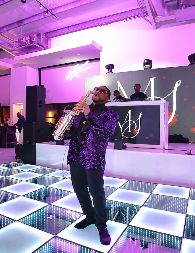 A saxophone player plays his music on the dance floor. 
